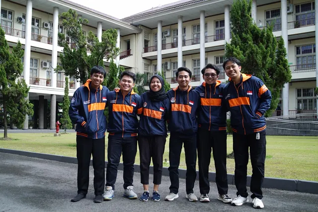 Enam anggota tim berjaket tim berdiri berjajar